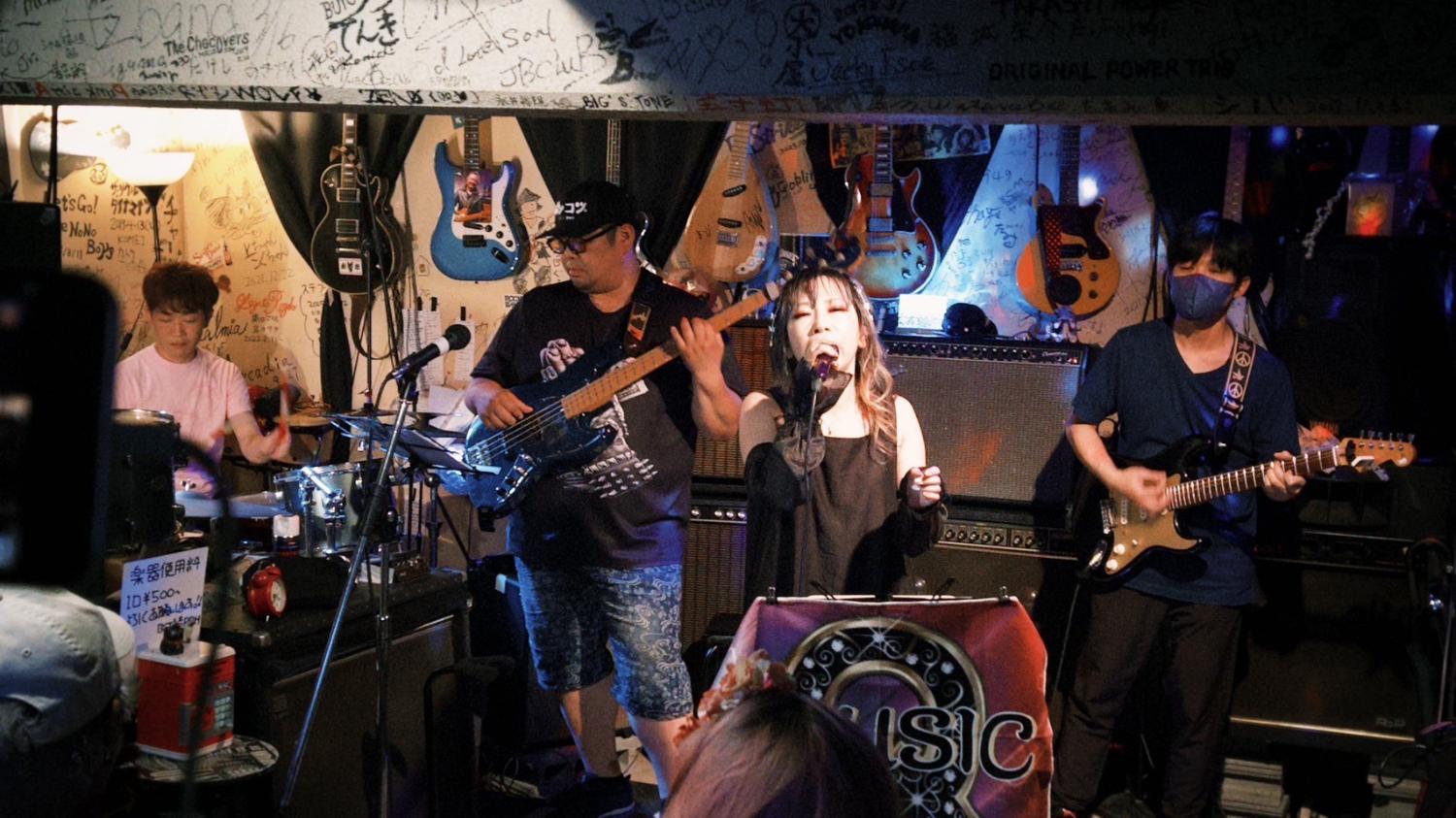 壁にギターが並ぶ自由が丘ライブハウス55。4人がフルで演奏する