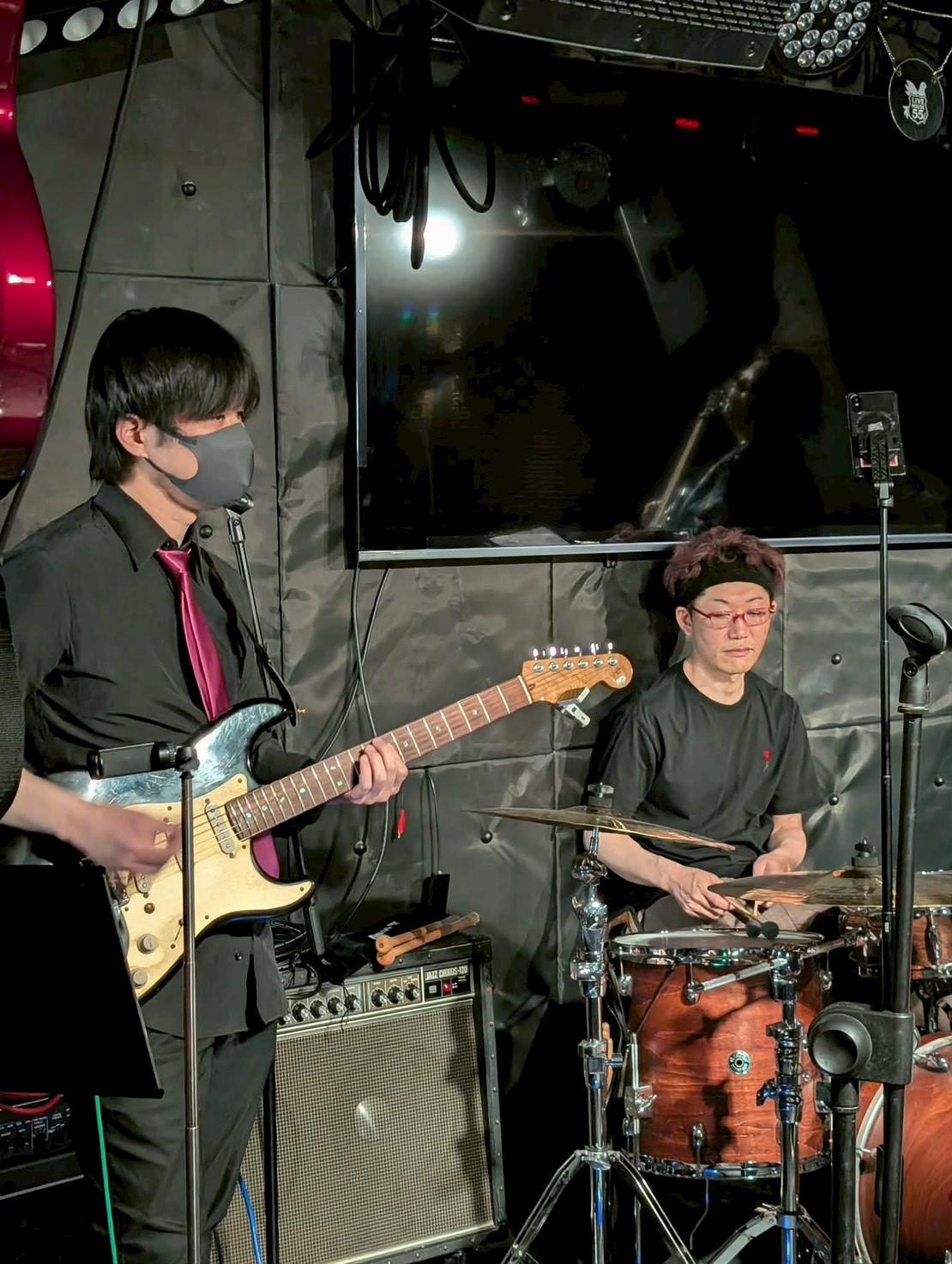 ライブハウス55。マスクの みっくん がギター、右でまこがドラム