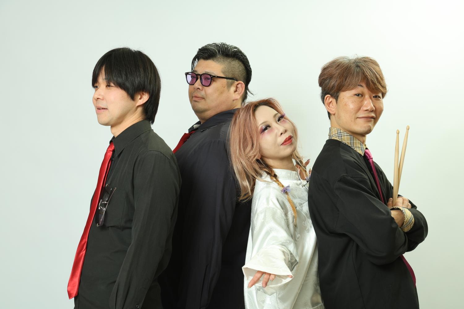 白い背景に背中合わせで立つQEUSIC。左から Gt.みっくん、Ba.のすけ、Vo.JUN、Dr.まこ