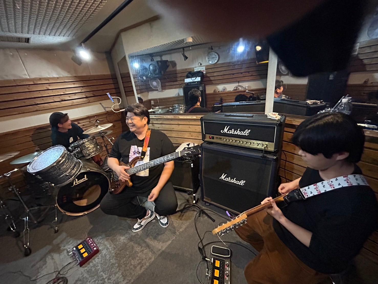 Marshallアンプの前で笑うのすけ。左にまこ、右にみっくん