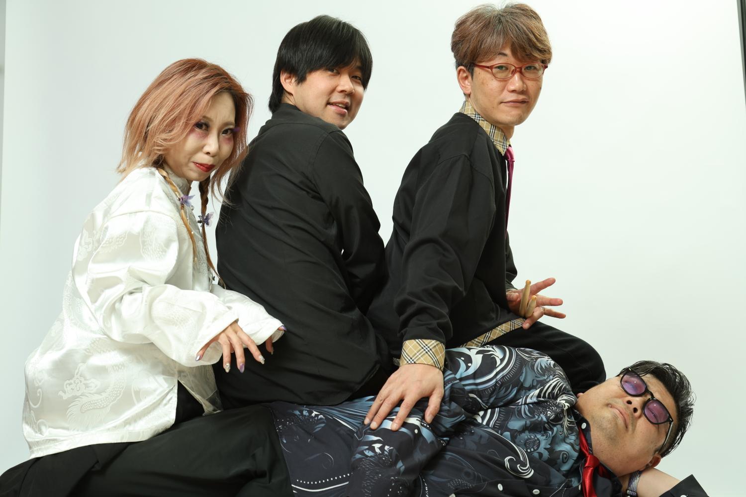 白い背景。JUN、みっくん、まこが、寝転ぶのすけの上に乗るスタジオショット