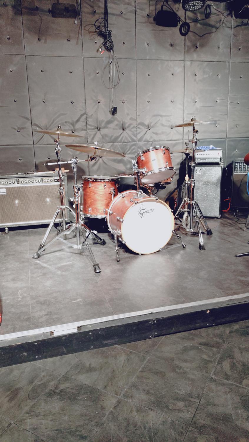 グレーの壁の箱。木目のGretschドラム、白いバスドラム